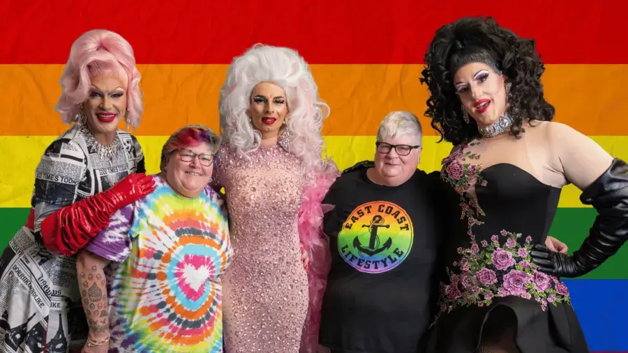A group of event attendees pose for photo with performers.