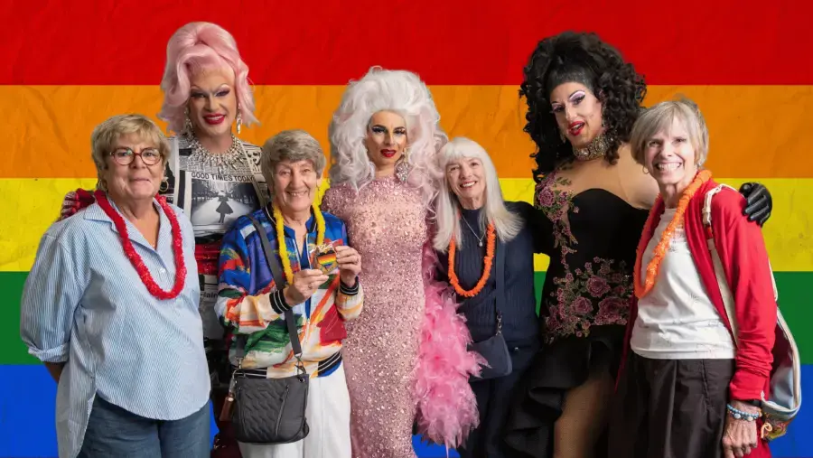 A group of event attendees pose for photo with performers.