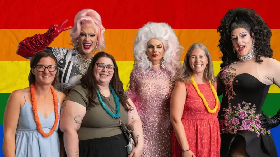 A group of event attendees pose for photo with performers.
