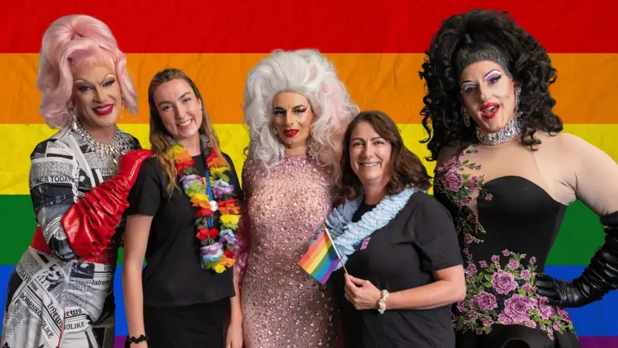 A group of event attendees pose for photo with performers.