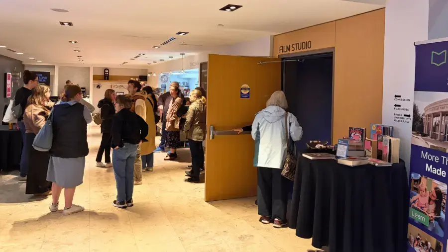 Guests gather outside The Film House theatre before a screening of The Librarians, chatting in groups and socializing before they grab their seats.
