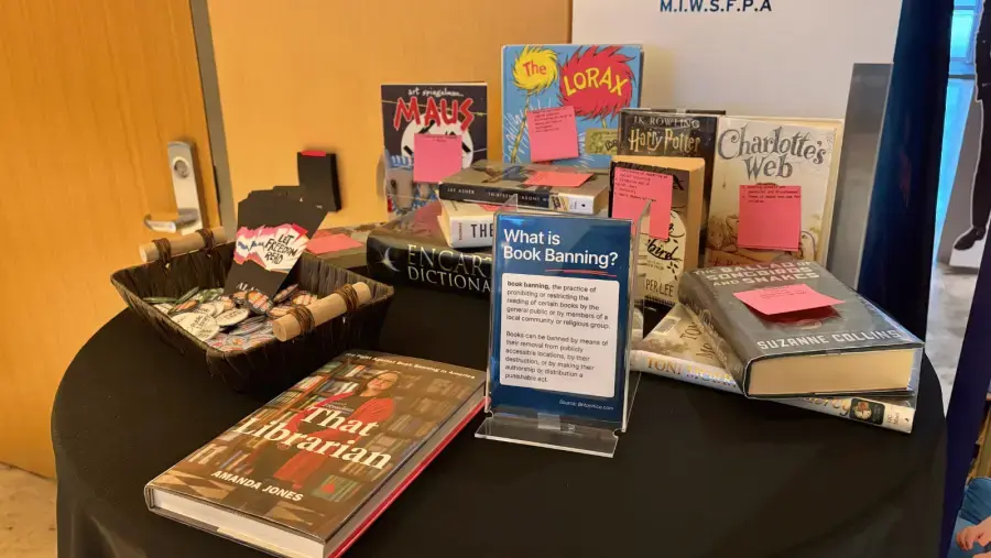 A collection of library advocacy buttons promoting banned books, intellectual freedom, and support for local libraries at a The Librarians community screening event.