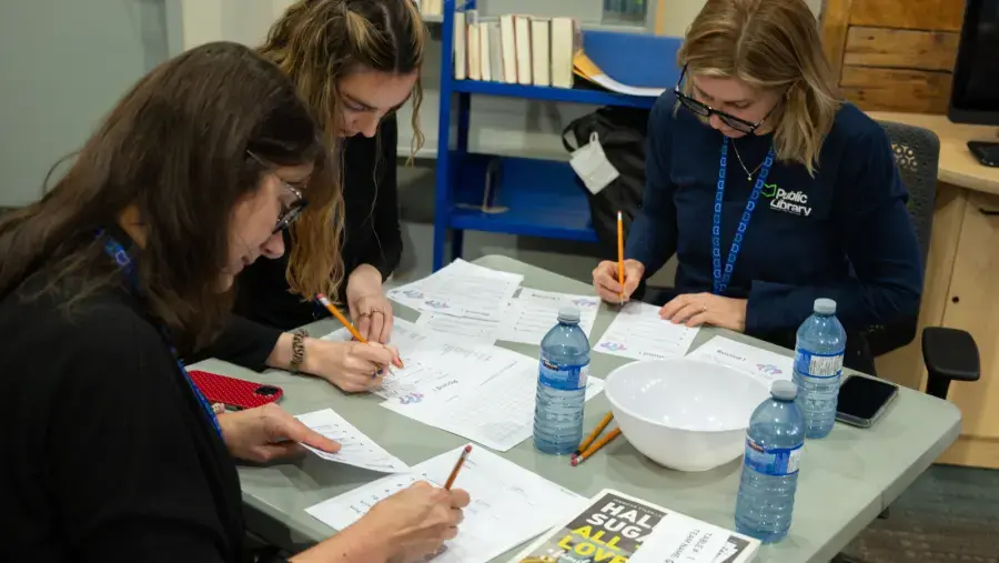 Staff and volunteers review answer sheets and tally scores.