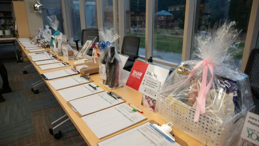 A long table filled with silent auction prizes.